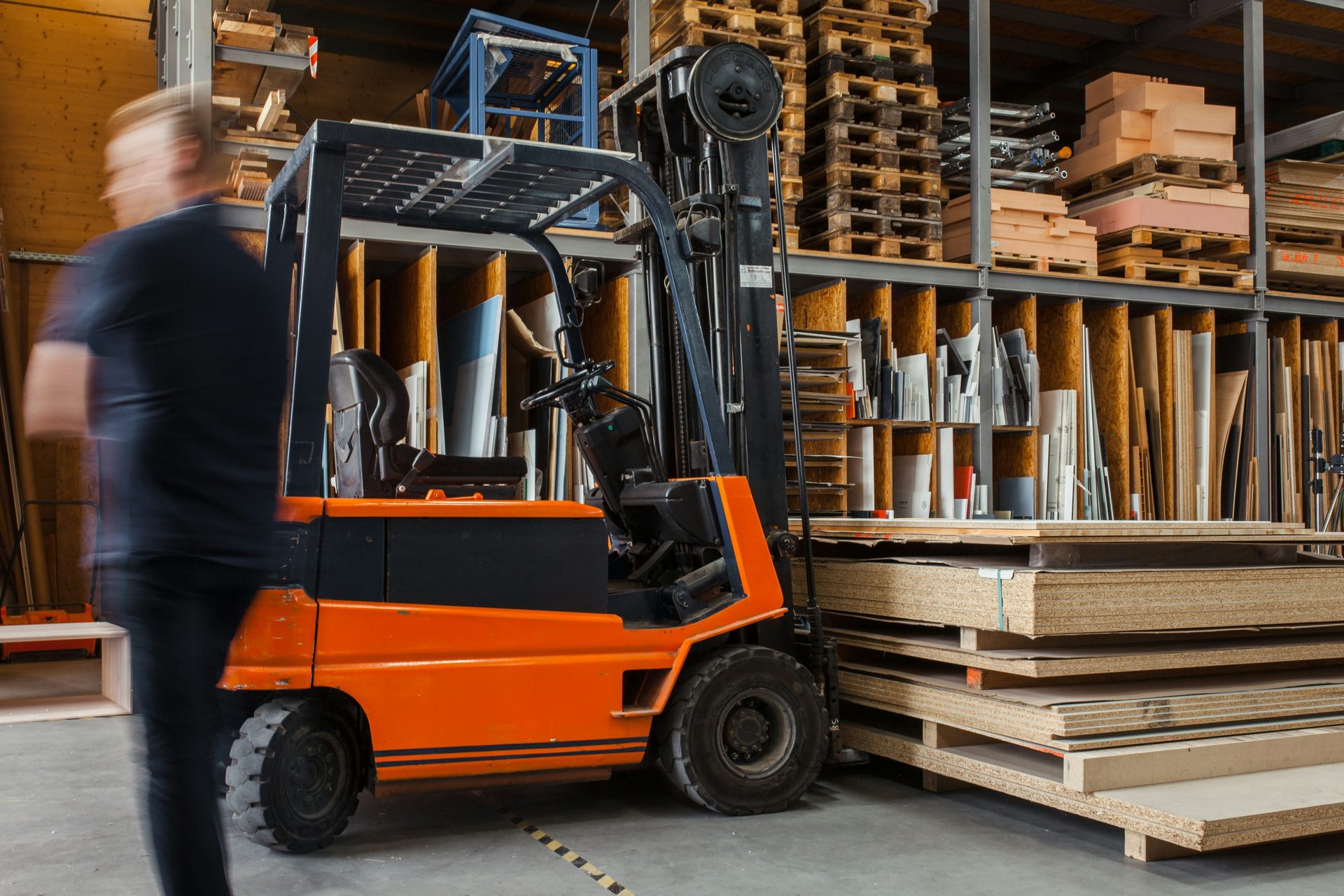 Operator moving a forklift through a materials warehouse