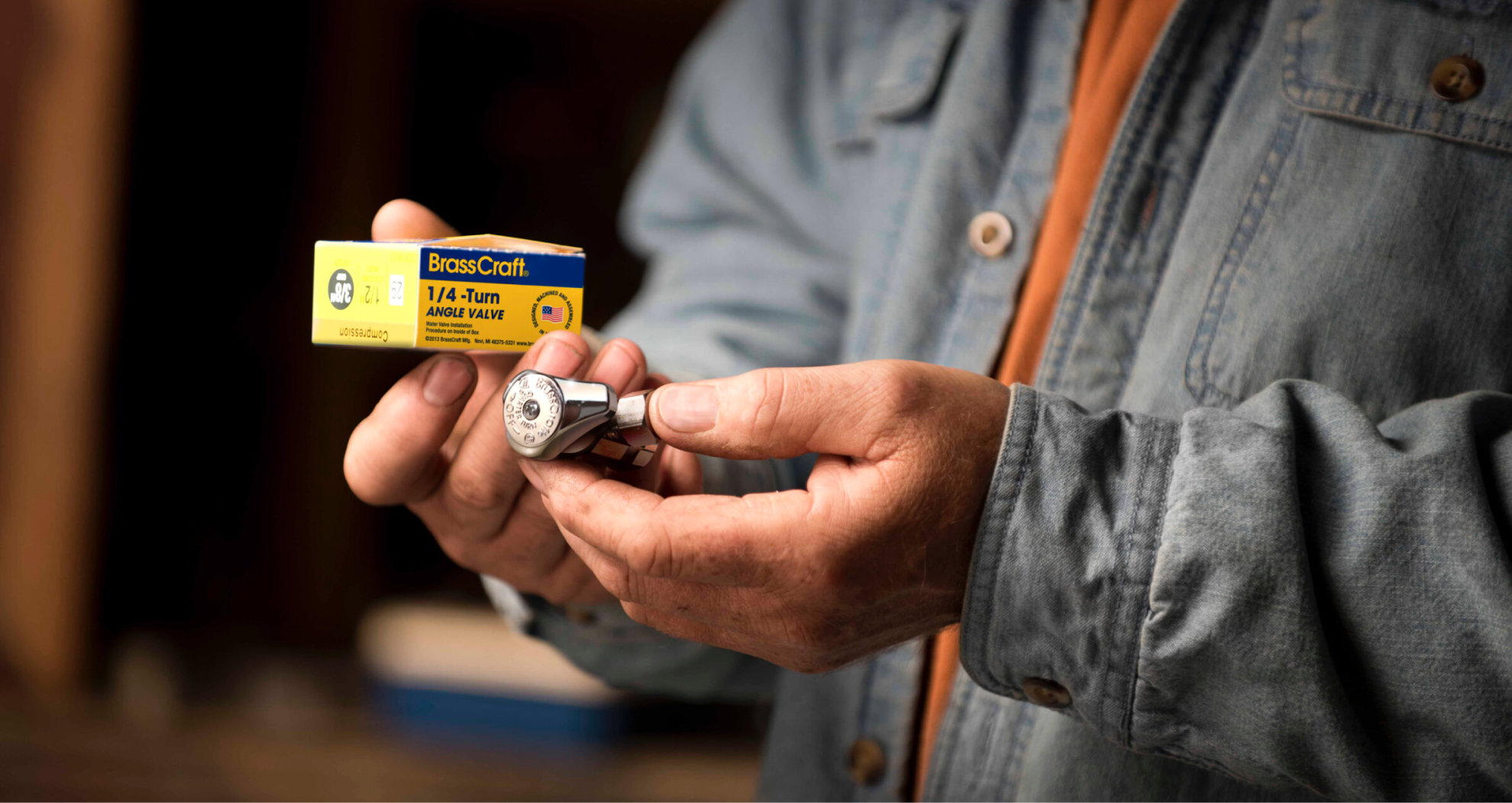 Tradesman holding a BrassCraft 1/4-turn angle valve and its box