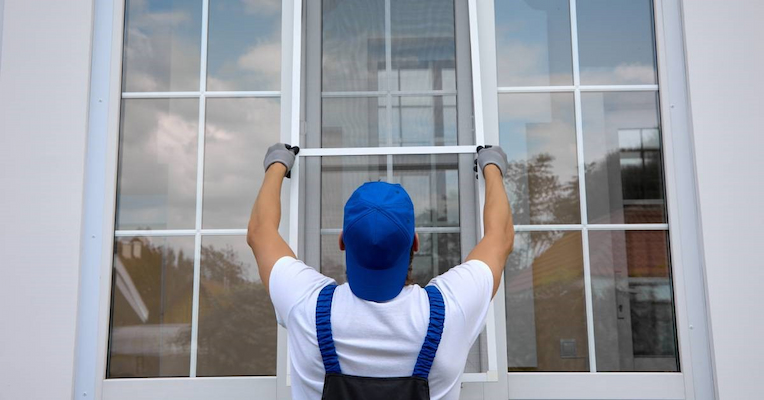 Installer fitting a new window on a home exterior
